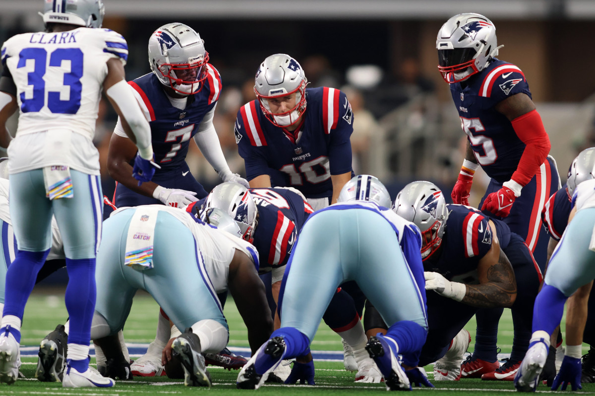 New England Patriots quarterback Mac Jones (10) attempts to rush for a first down in the second quarter against the Dallas Cowboys at AT&T Stadium.